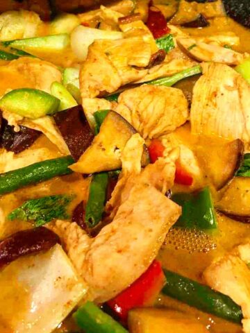 Chicken in red curry sauce with green string beans, eggplant, red and green bell pepper, bokchoy, shiitake mushrooms and kaffir lime leaves.