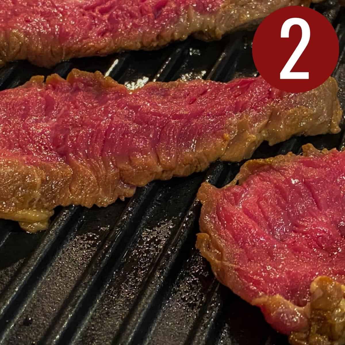 Slices of Filipino beef steak on a griddle.