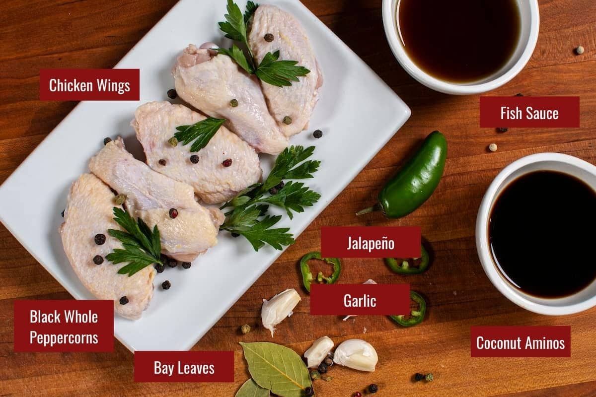 Ingredients for chicken wing adobo on a wooden board.
