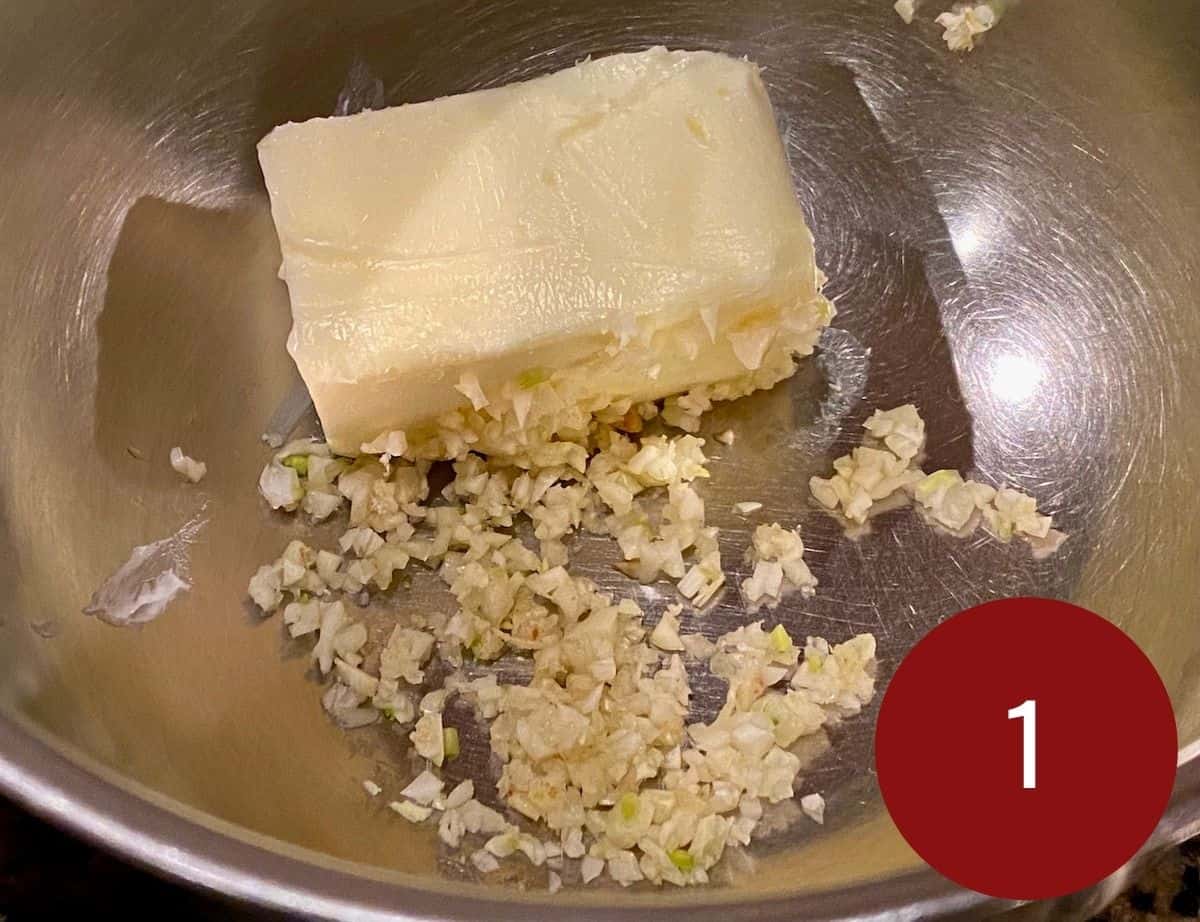 Minced garlic and butter in a stainless steel bowl.