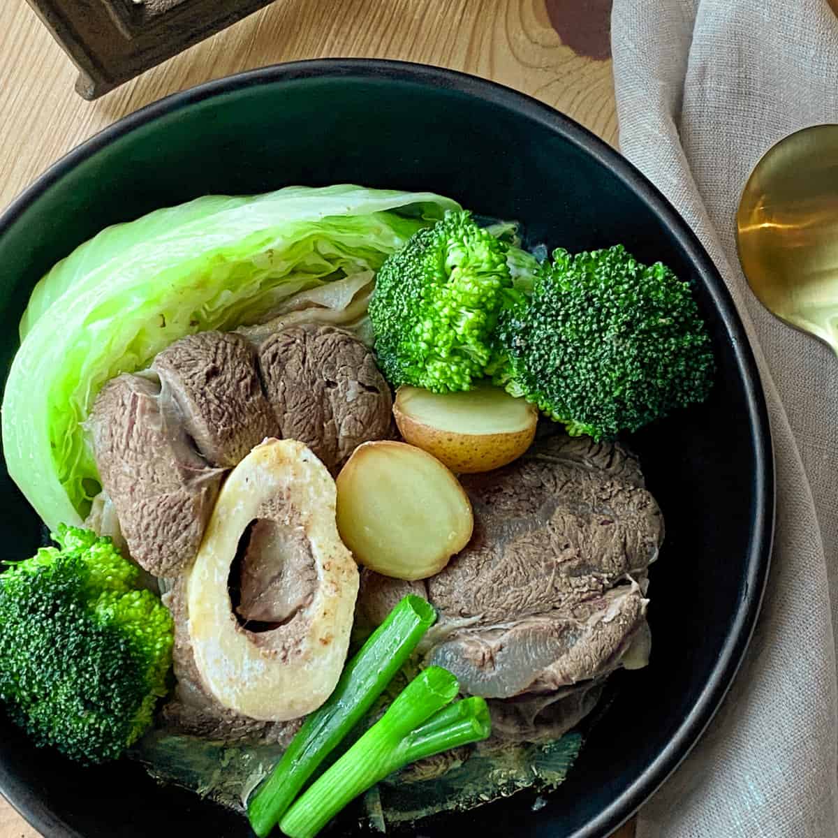 Beef Nilaga (Bulalo) in a black bowl.