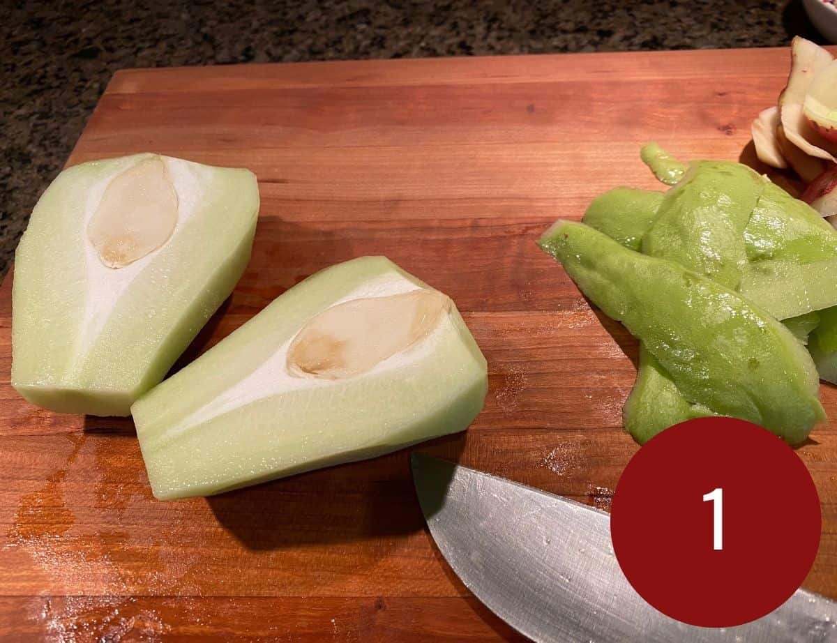 Sliced chayote with a knife next to it on a wooden board.