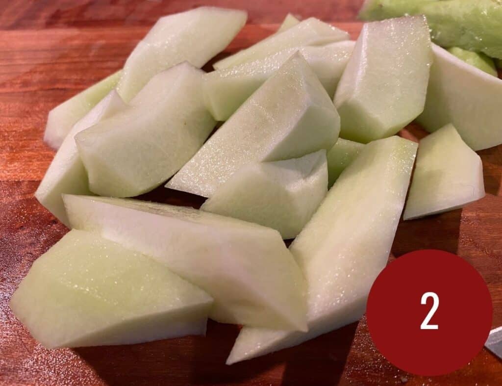 Sliced chayote pieces on a wooden board