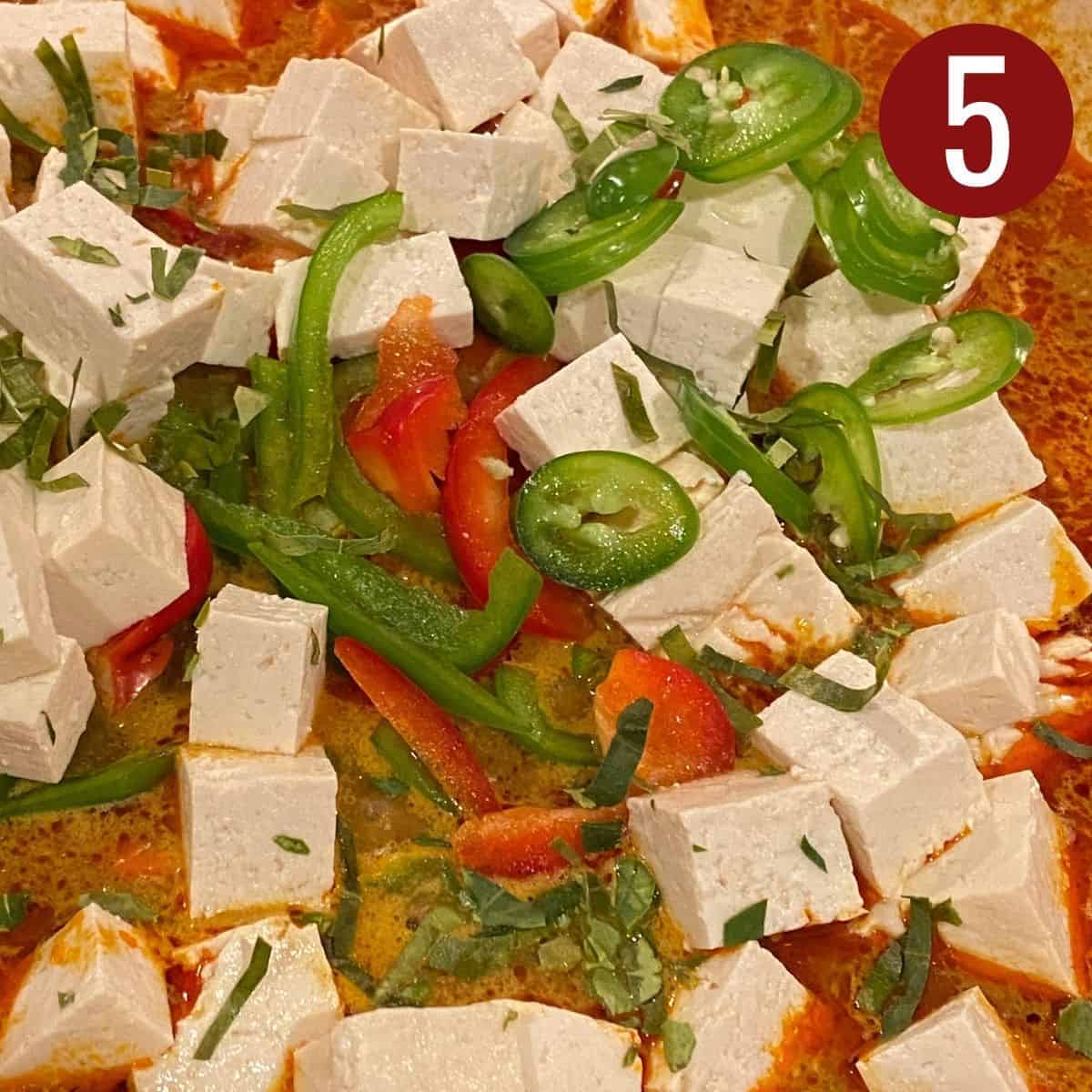 Tofu with sliced peppers in red curry sauce.