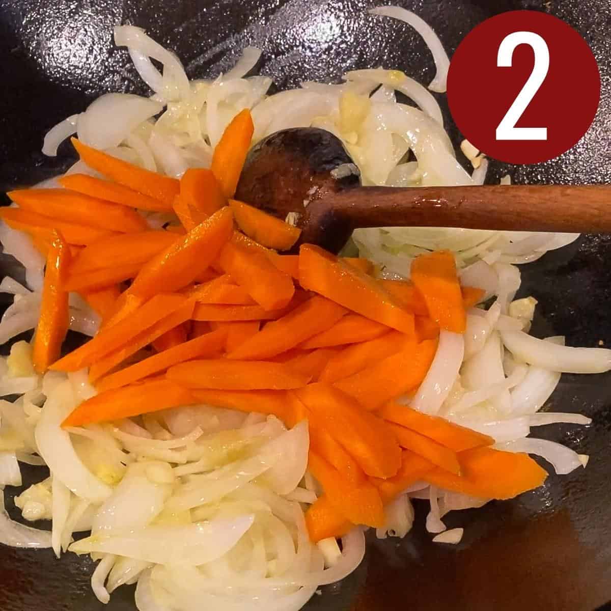 Step 2 sliced carrots with garlic, ginger, and sliced onion on a skillet.