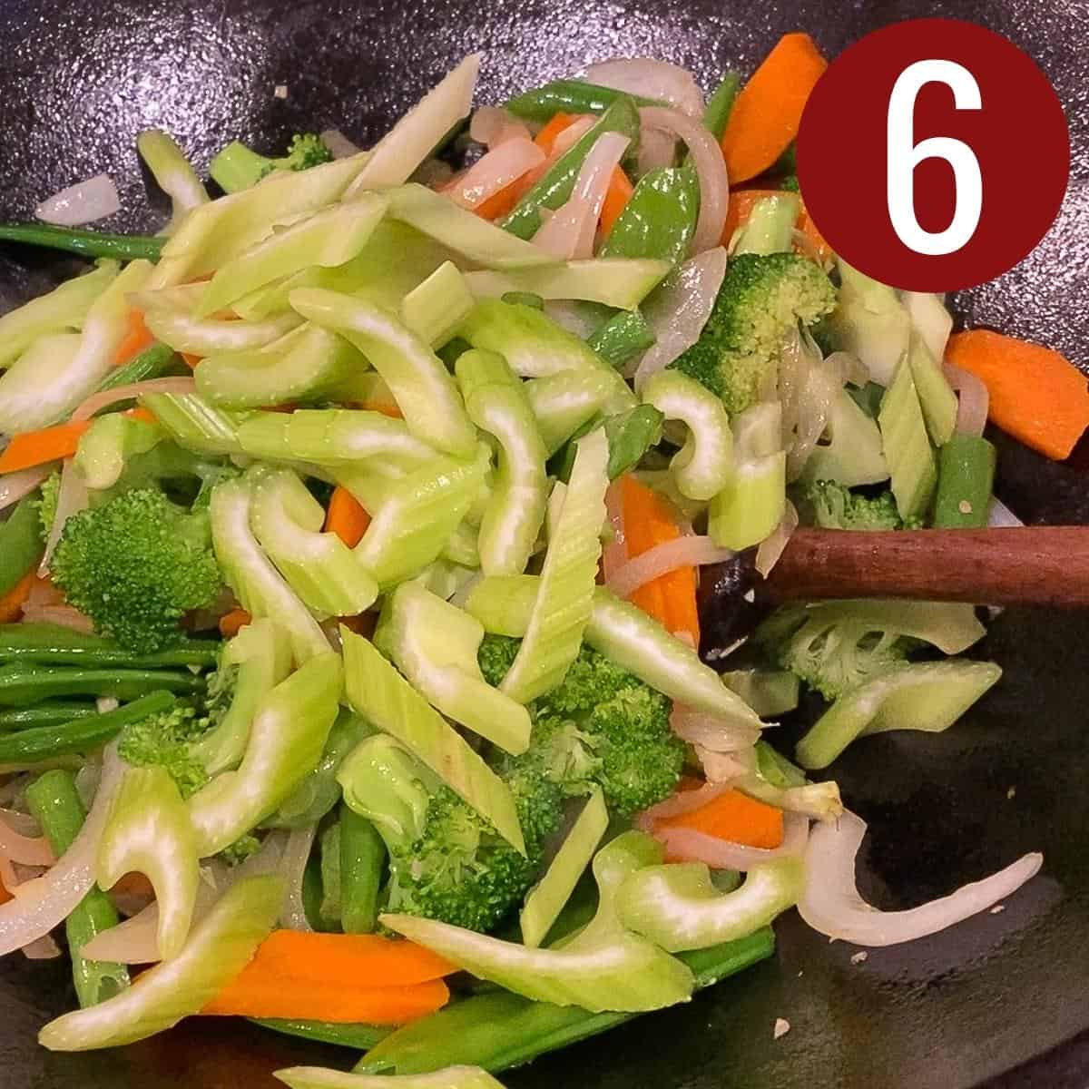 Step 6 celery, pea pods, green beans, carrots, garlic, ginger, onion, in a wok.
