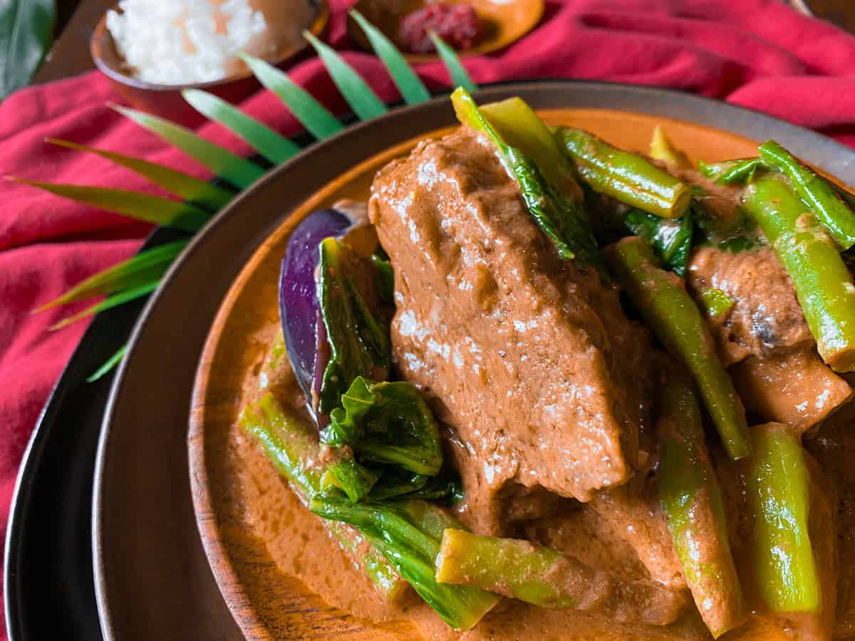 Short ribs kare kare on a wooden plate.