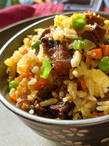 Close up of steak fried rice in a bowl.