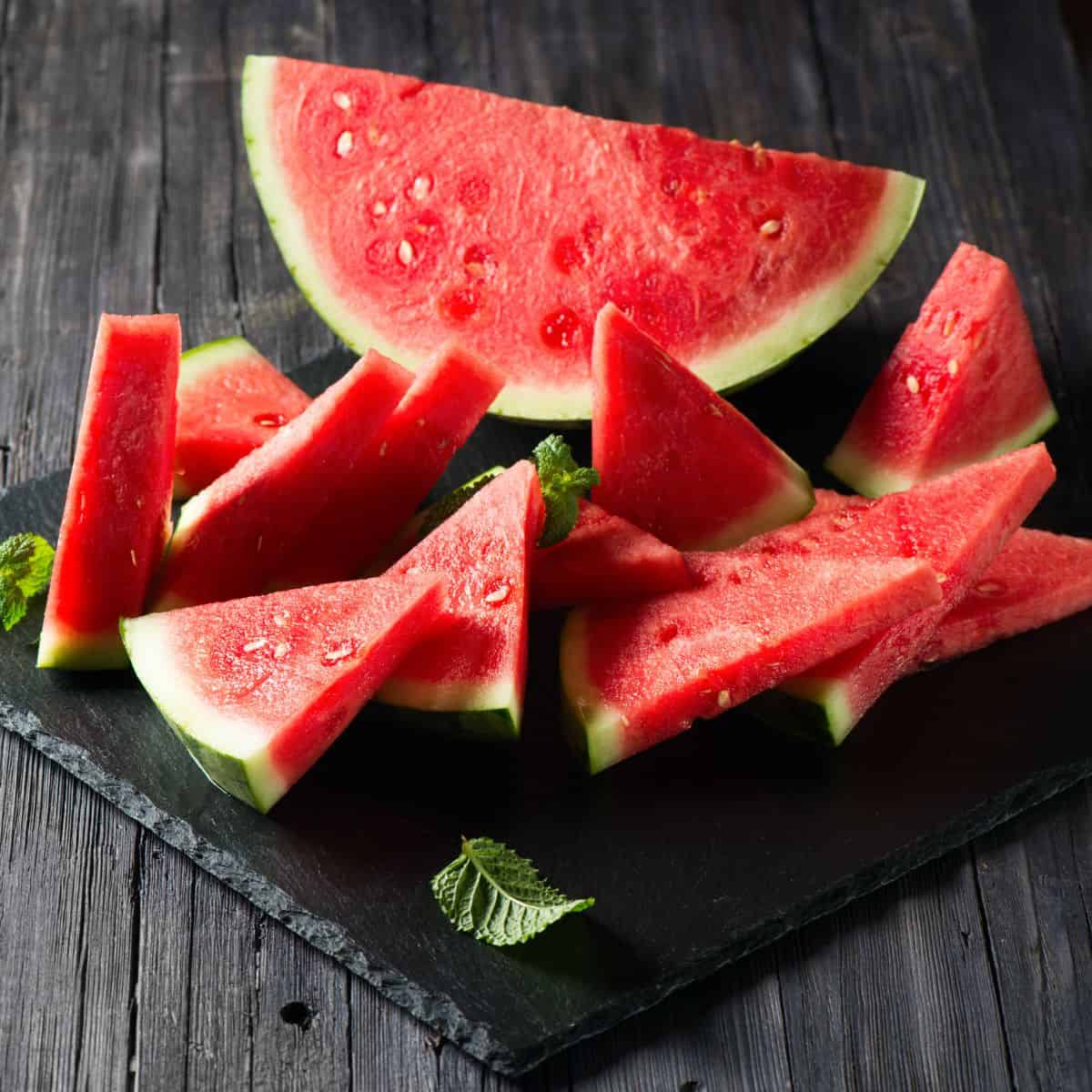 Watermelon slices on a wooden board.