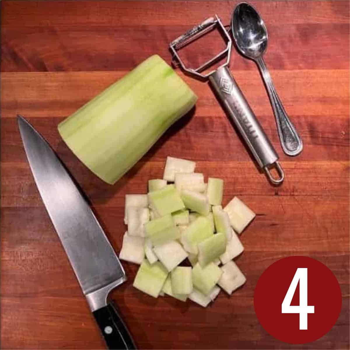 Cut up opo squash on a wooden board with a knife and vegetable peeler next to it.