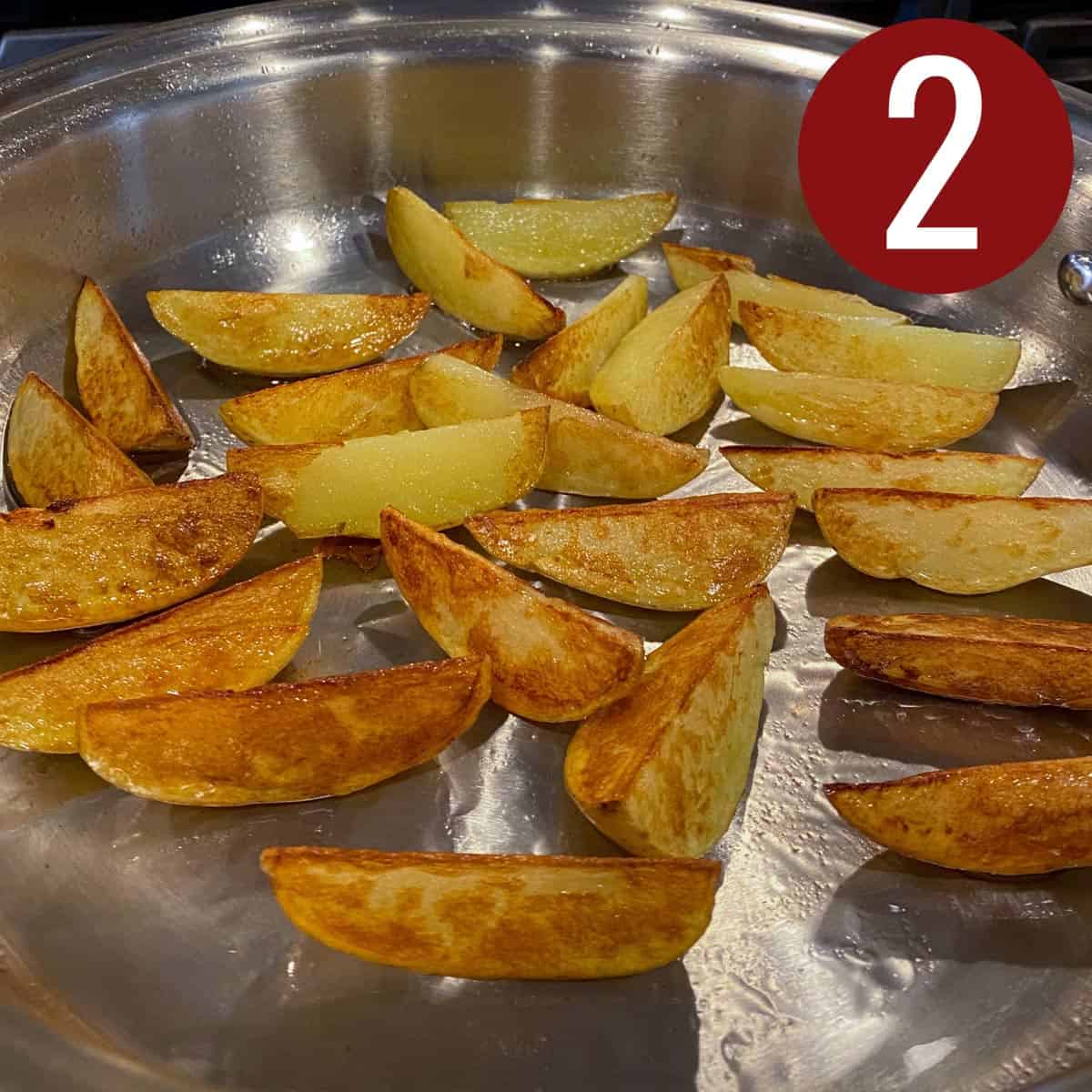 Browned potato wedges for beef stir fry on a skillet.