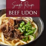 Beef udon in a black bowl.
